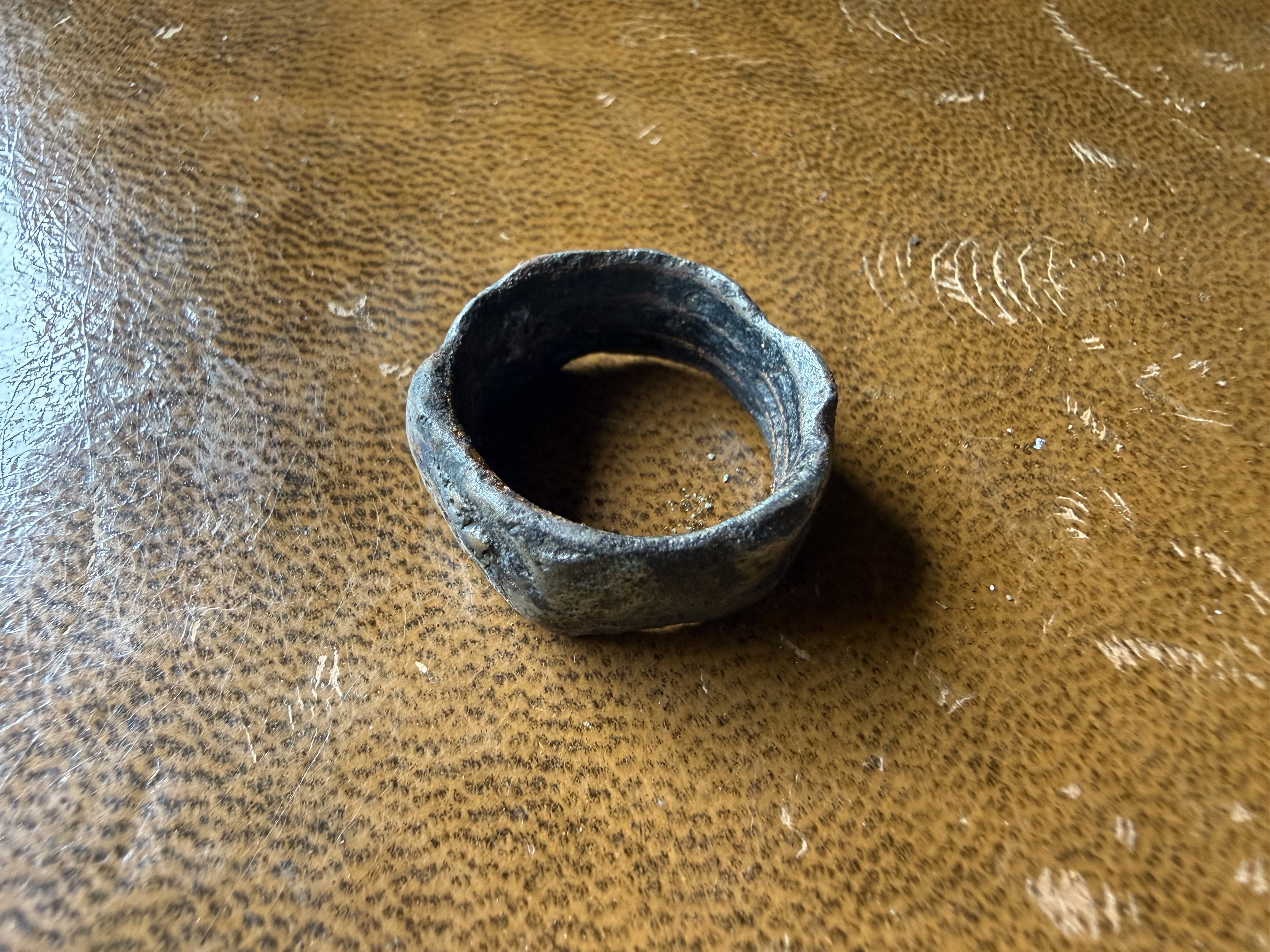 Heavily corroded lead or pewter ring with faceted outer edge, found by metal detecting